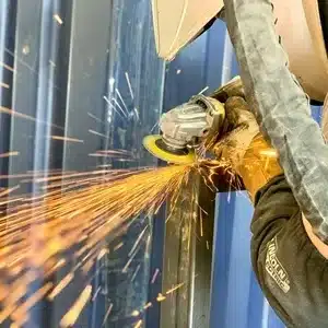 Metal fabricator welding a steel frame in a workshop